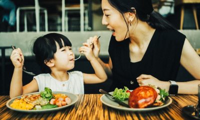 A woman and child eating food.